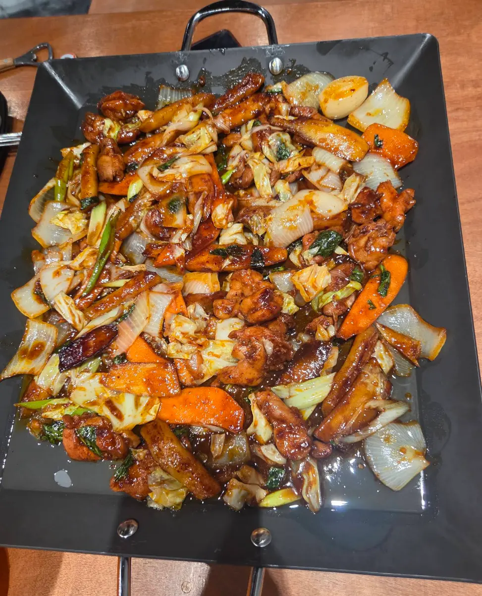 검은 팬에 담겨 나온 비와이 On Lao의 닭갈비
