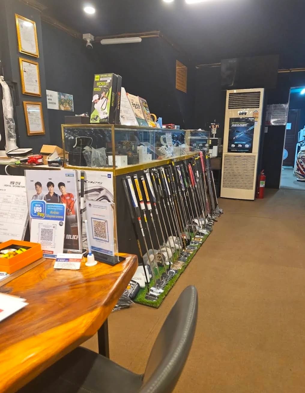 K GOLF샵 계산대와 클럽 진열 랙, 왼쪽에 놓인 렌탈 안내판