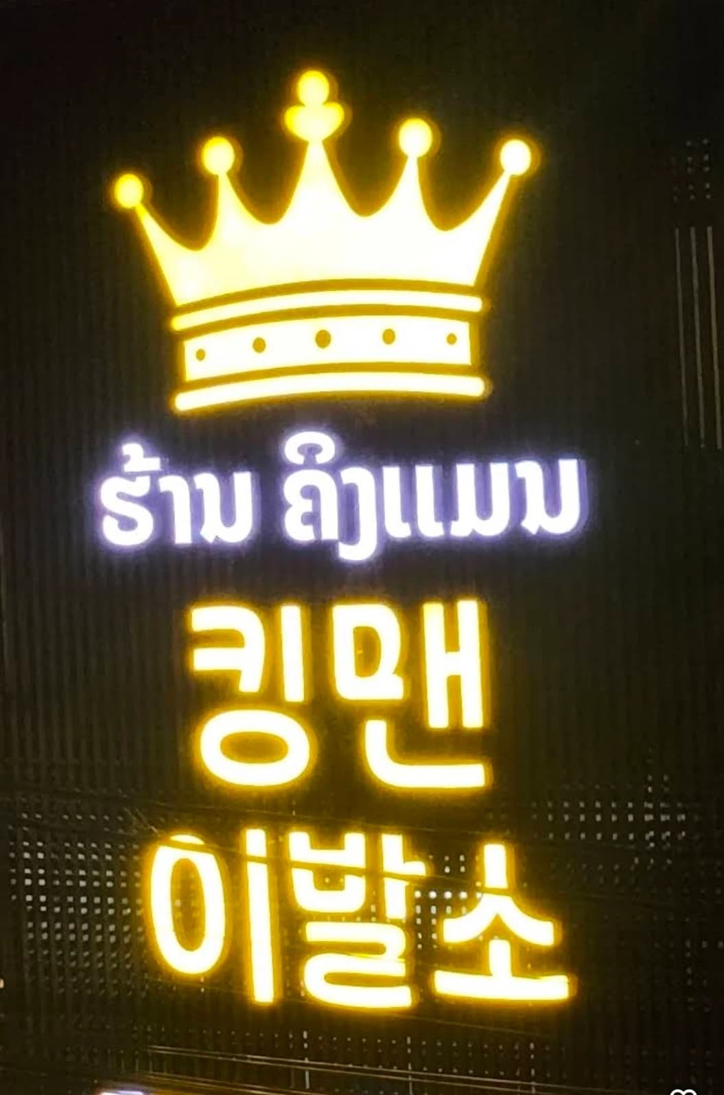 킹맨이발소의 금색 왕관 네온 간판과 라오어 상호 ຮ້ານ ຄິງແມນ