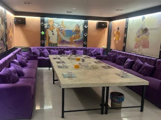 보스 가라오케 보라색 소파와 벽면 그림이 있는 룸